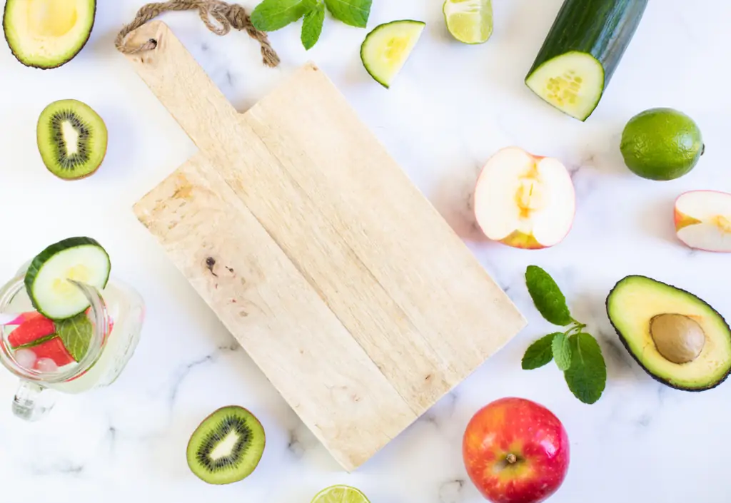 Des produits frais, fruits et légumes, alignés sur une planche en bois